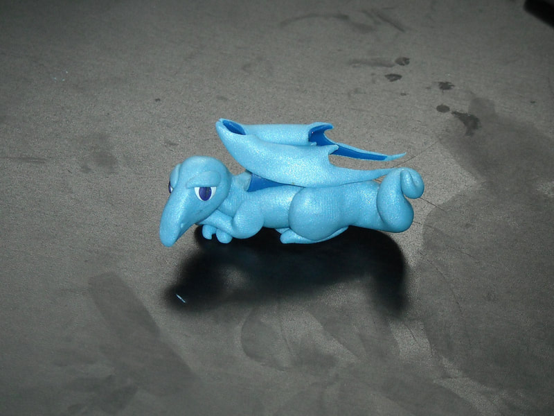 A very small sparkly blue polymer clay dragon