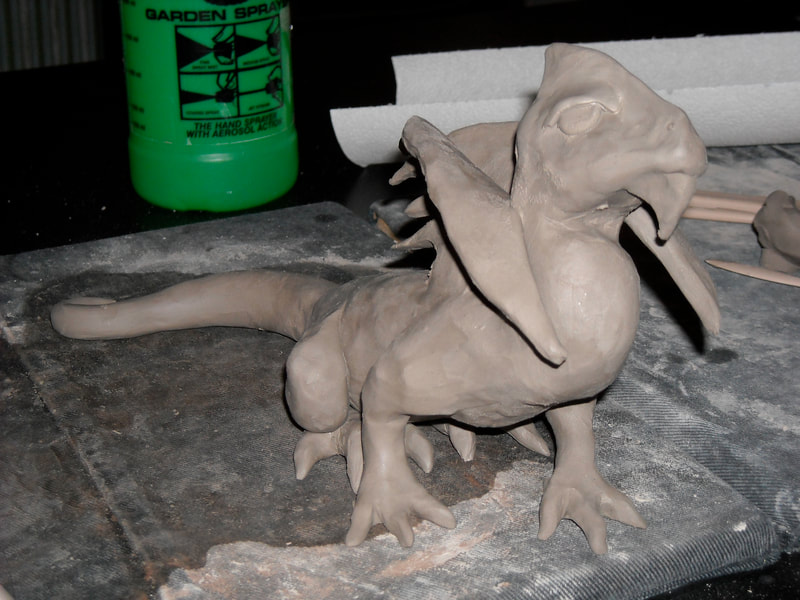 Progress photo of a still wet clay dragon